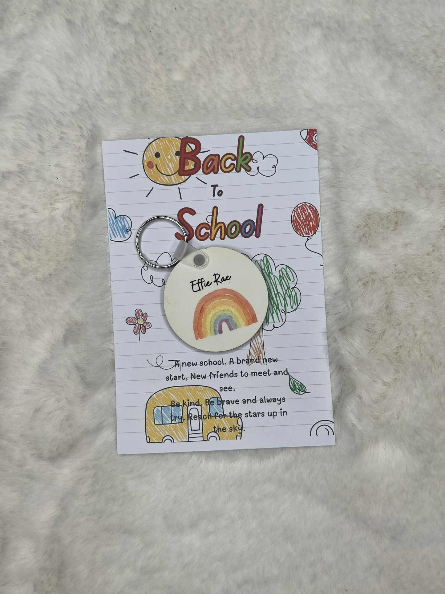 Keychain with rainbow design on a 'Back to School' themed card with text.