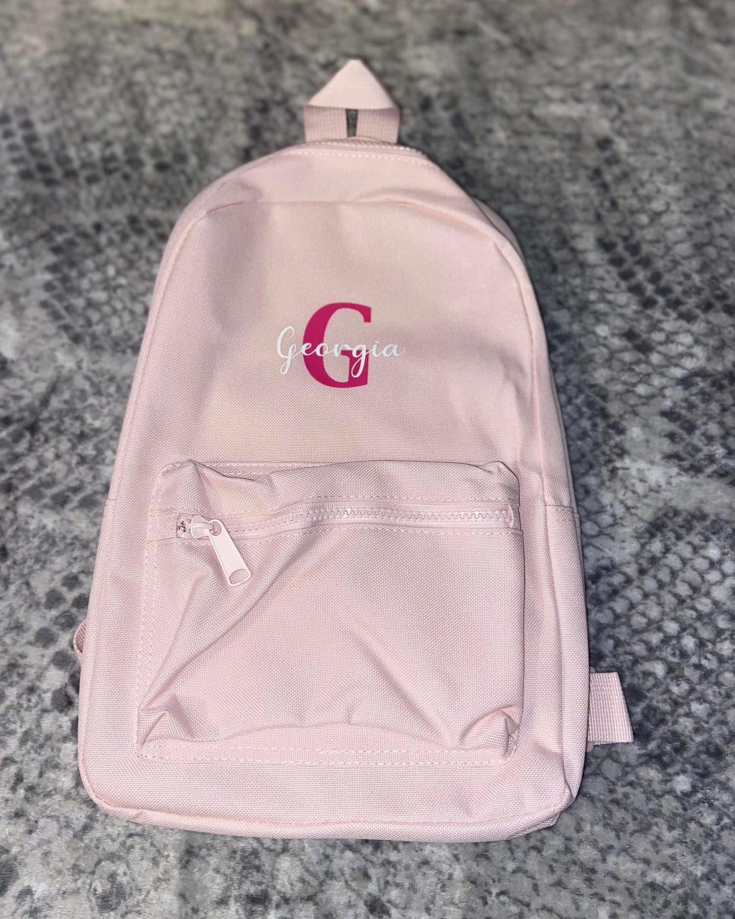 Light pink 7 litre backpack with custom text in pink and white