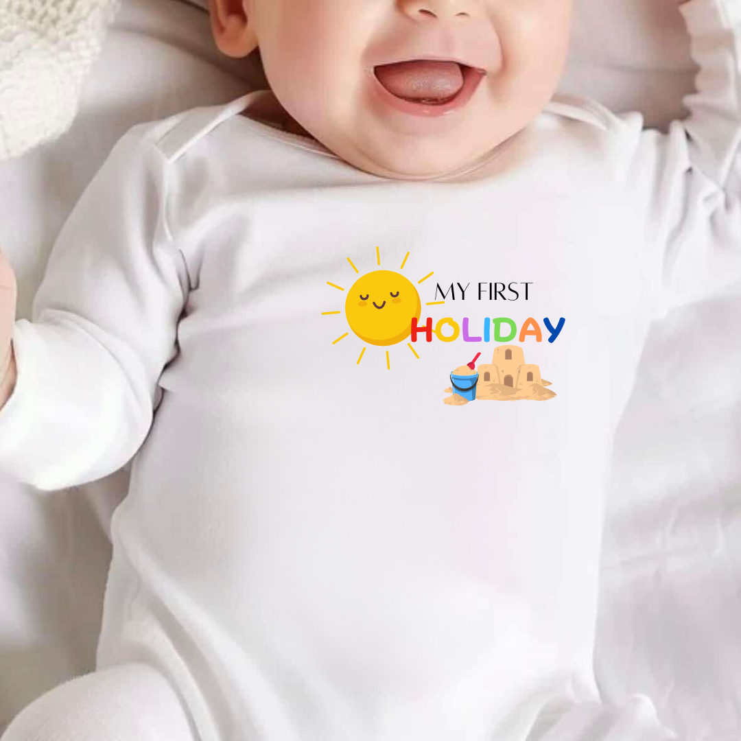 white baby vest with image of sun and a sandcastle with text ' My First Holiday, Personalised with child's name