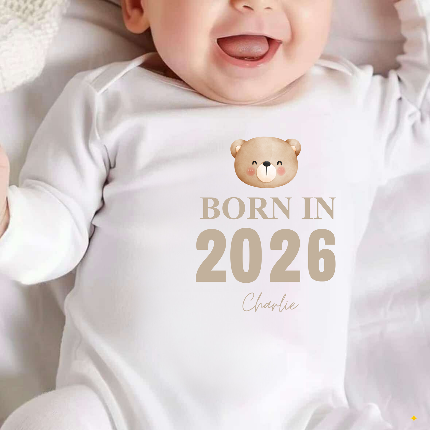Baby wearing a white onesie with a bear graphic and 'Born in 2026' text.