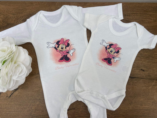 Two white baby sleepsuits with character designs, one long-sleeved and one short-sleeved,