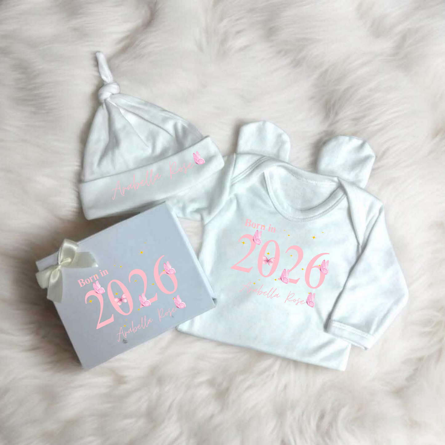 Baby outfit set with 'Born in 2026' text on a soft surface