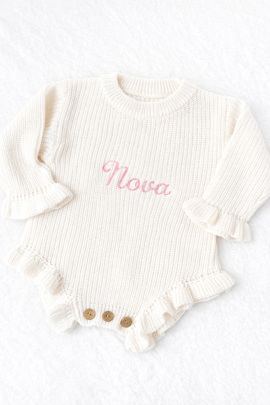White ribbed baby romper with 'Nova' embroidery on a white background