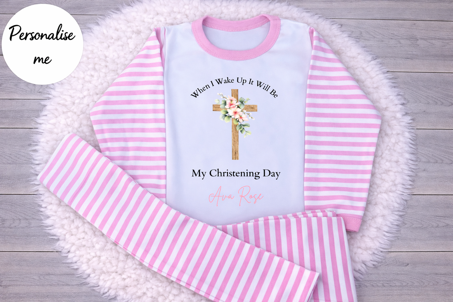 Pink and white striped pajama set with a personalized message on a wooden surface.