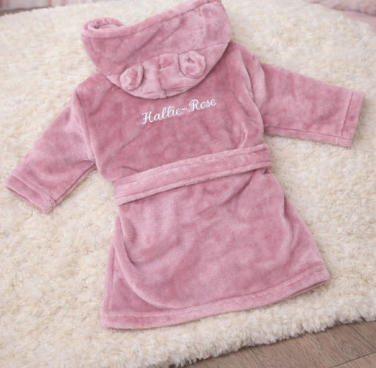Pink children's robe with 'Hallie-Rose' embroidered on a fluffy white surface