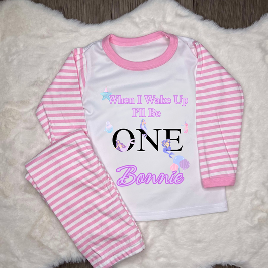 Pink striped pyjamas with text when I wake up I’ll be 1 with name and images of mermaid’s 