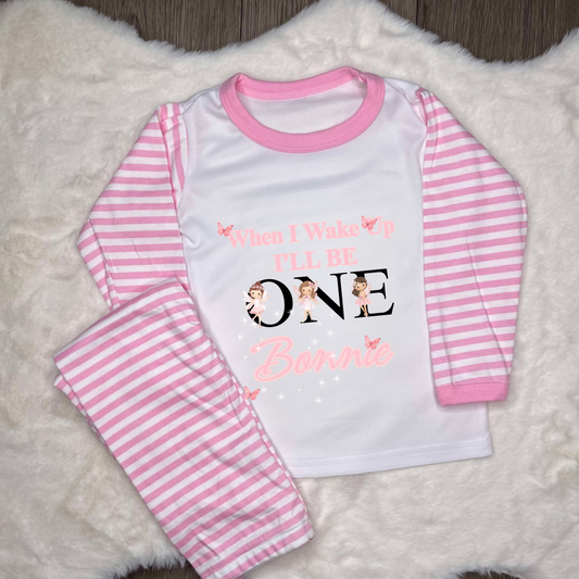 Pink Striped pyjamas with text when I wake up I’ll be 1 with a name and images of fairy in pink little dress 