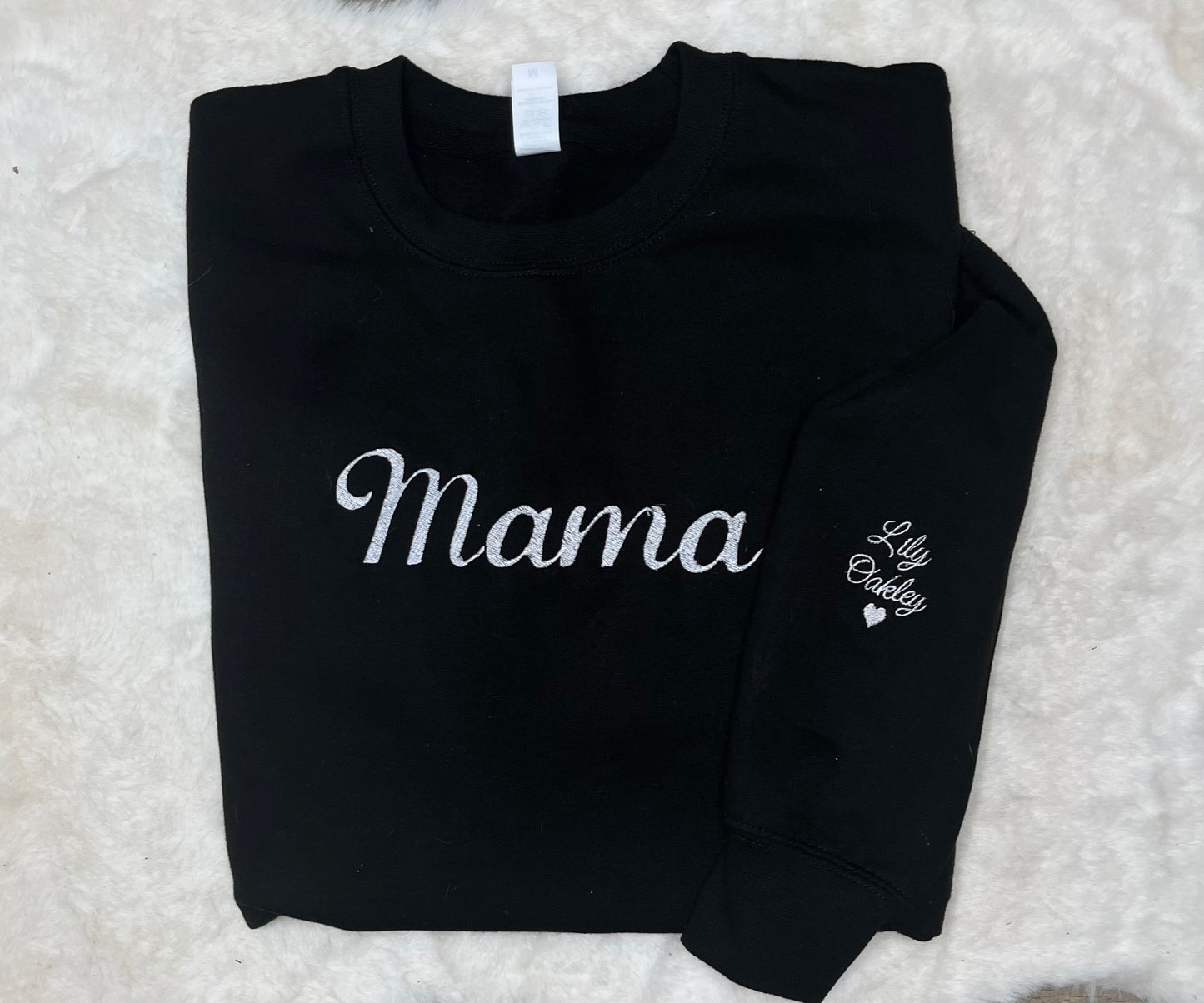 Black sweatshirt with 'Mama' and 'Lily Oakley' text on a textured white background