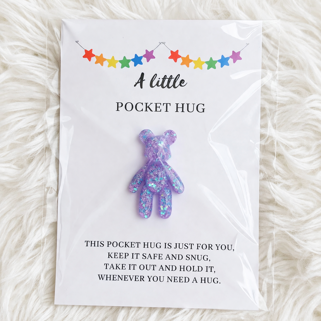 Purple glittery pocket hug toy on a card with text on a white fluffy background