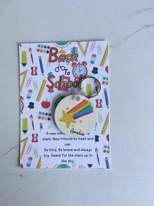 Keychain with star and rainbow design on a 'Back to School' themed card.