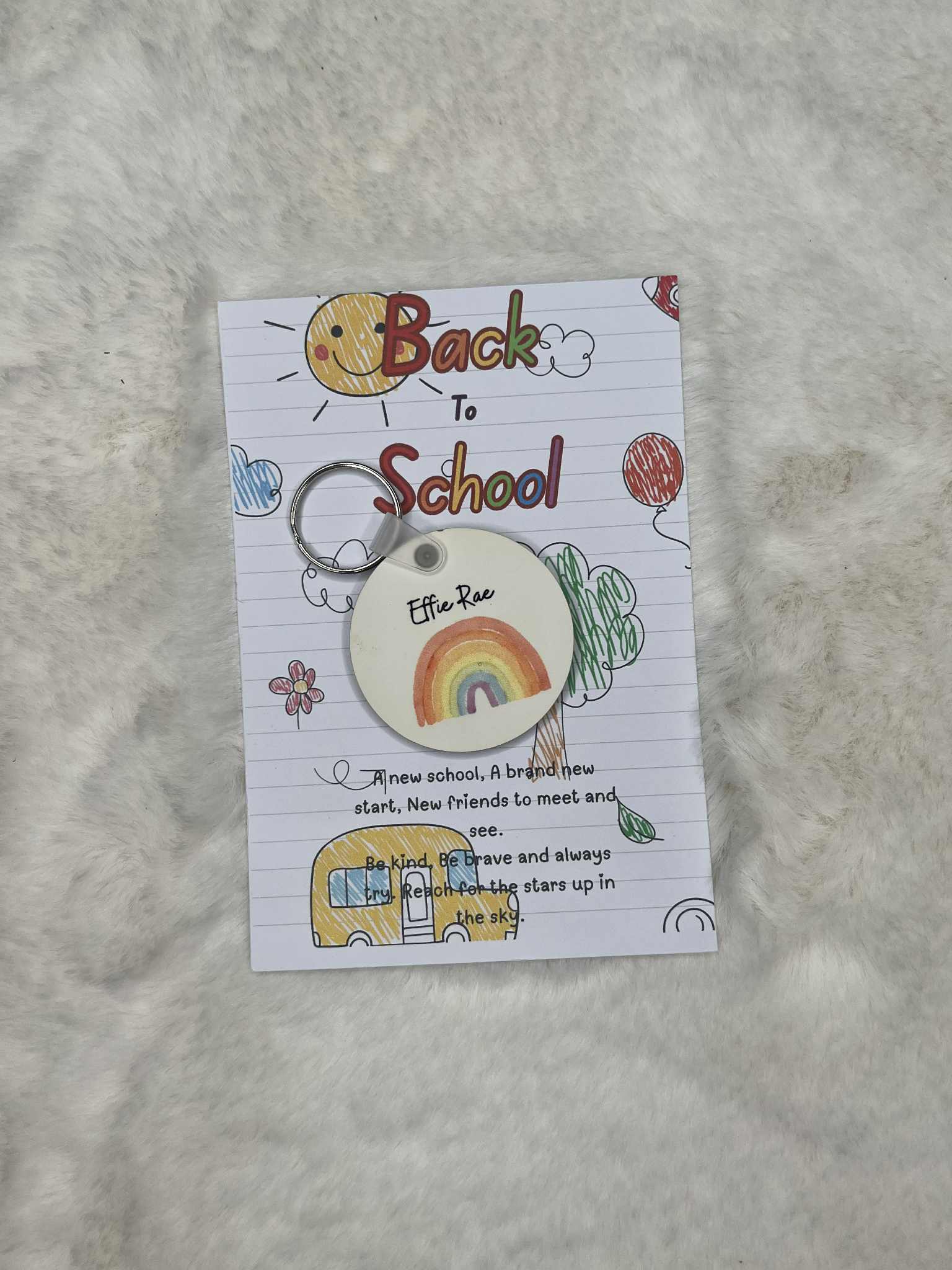 Keychain with rainbow design on a 'Back to School' themed card with text.