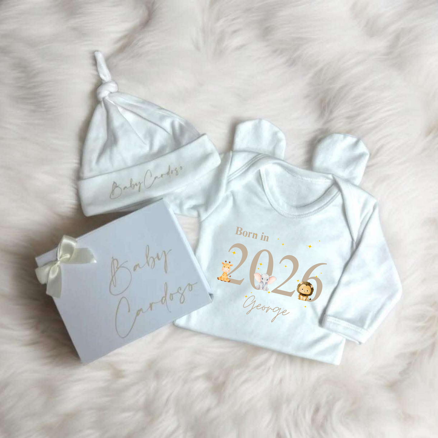 Baby clothing set with 'Born in 2026' design on a soft surface