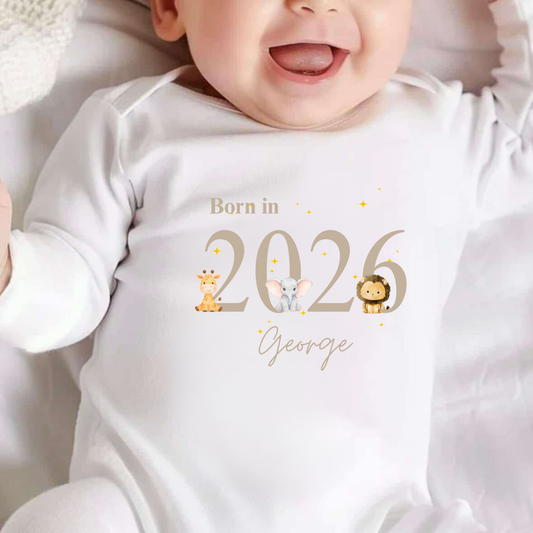 Baby wearing a white onesie with 'Born in 2026 George' printed on it.
