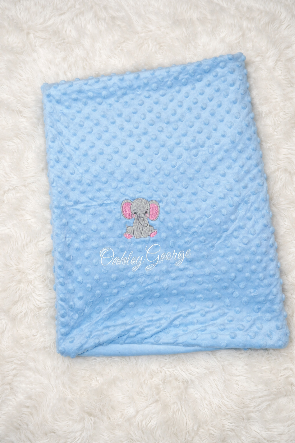 Blue textured blanket with a logo on a white background