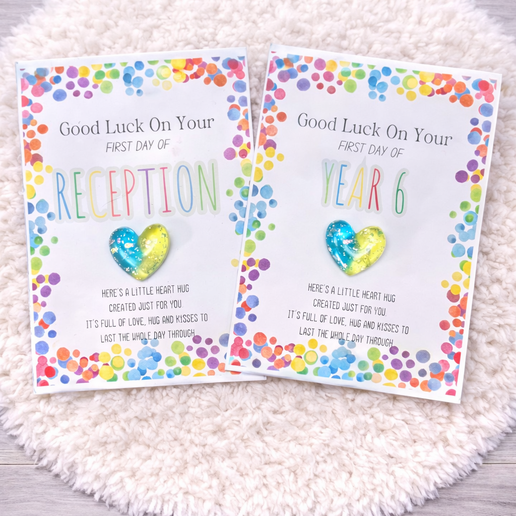 Two colorful greeting cards for school milestones on a textured white surface.