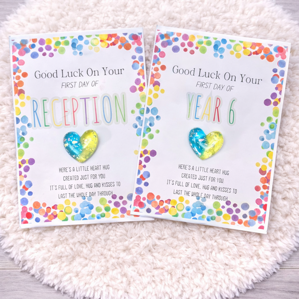 Two colorful greeting cards for school milestones on a textured white surface.