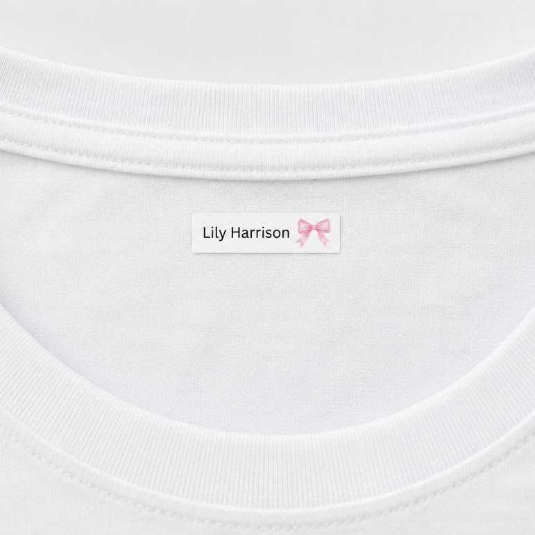Close-up of a white crewneck t-shirt showing the inside neck label with the text 'Lily Harrison' and a small pink bow graphic.