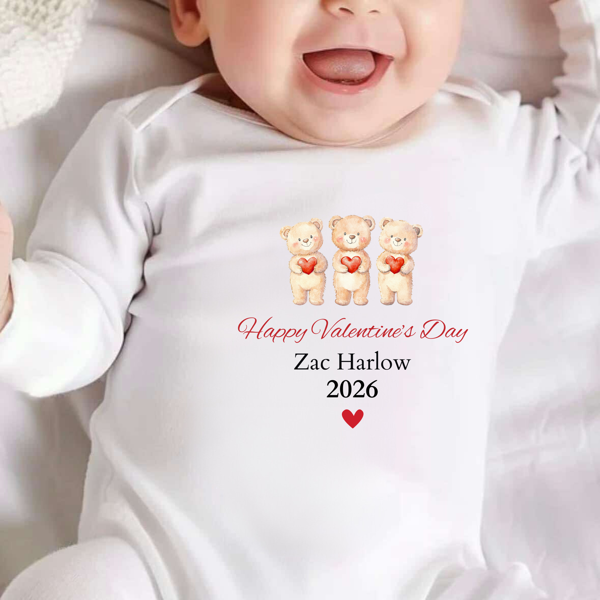 Baby wearing a white onesie with Valentine's Day design and text.