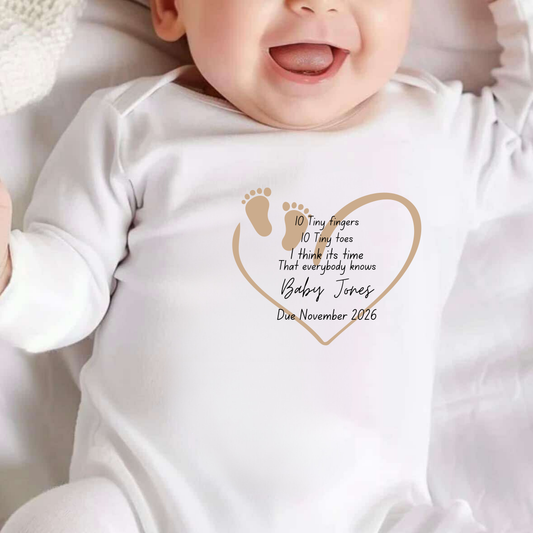 Baby wearing a white onesie with personalized text and design
