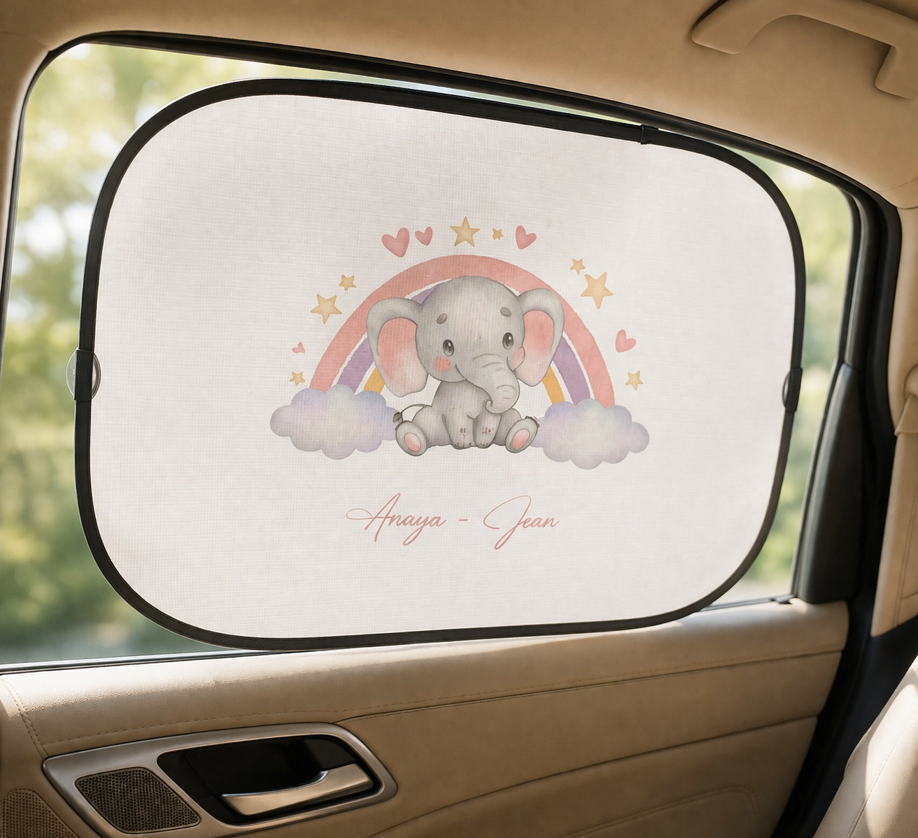 Car sunshade with an elephant design and rainbow inside a vehicle.