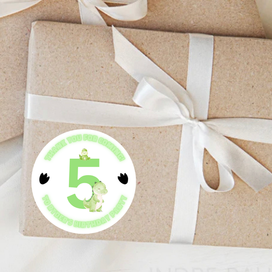 Gift wrapped in brown paper with a white ribbon and a green number 5 sticker featuring a dinosaur.
