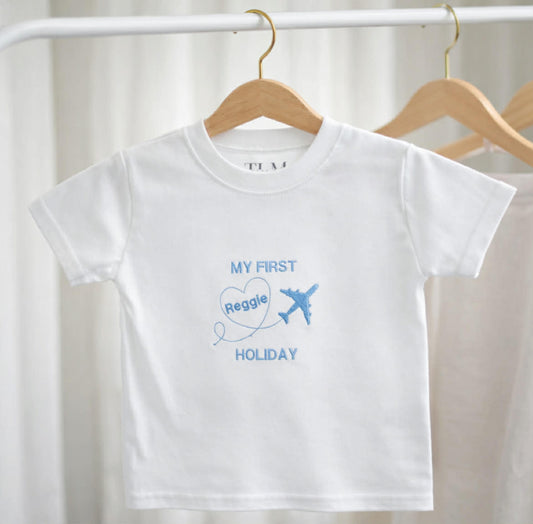 White t-shirt with blue text and airplane graphic on a hanger against a white background