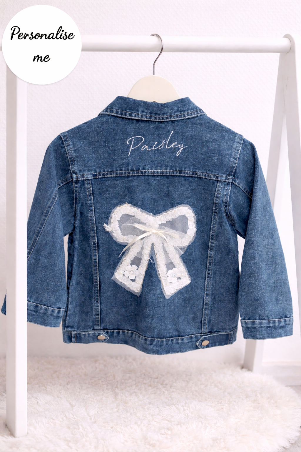 Denim jacket with a lace bow design and 'Paisley' text on a white background