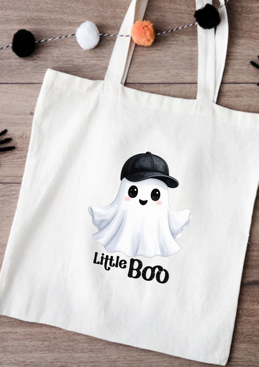 Tote bag with a ghost wearing a cap and 'Little Boo' text on a wooden surface.