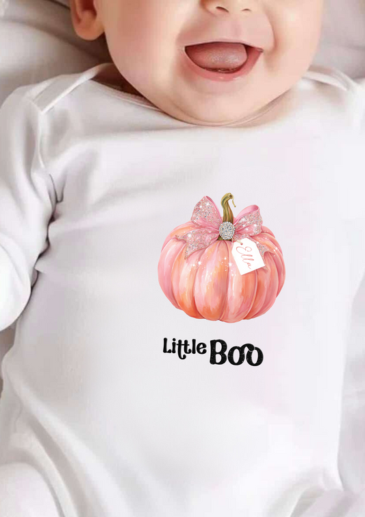 Baby wearing a onesie with a pink pumpkin and 'Little Boo' text