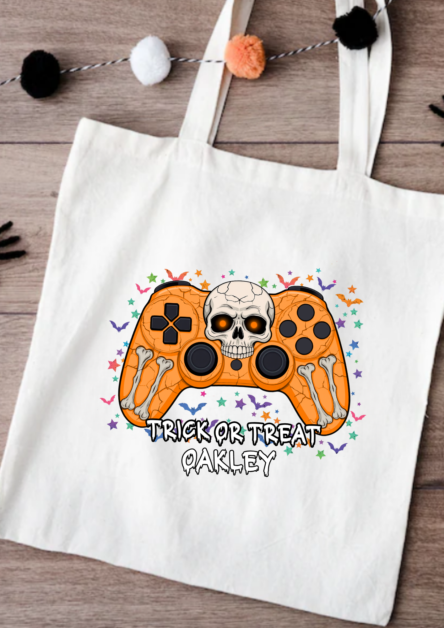White tote bag with Halloween-themed design featuring a skull and text on a wooden surface.