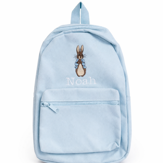 Light blue backpack with embroidered character and 'Noah' text on a white background