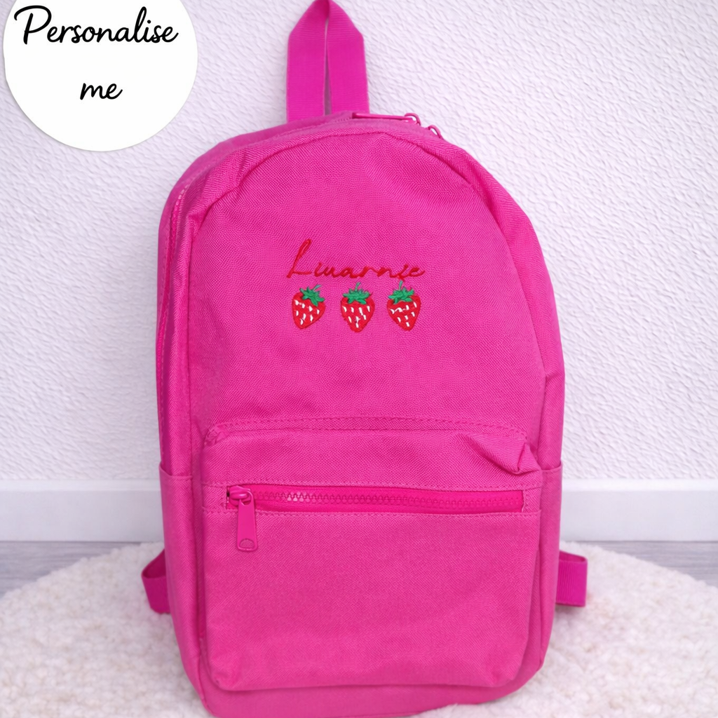 Pink backpack with embroidered name and strawberries on a white background