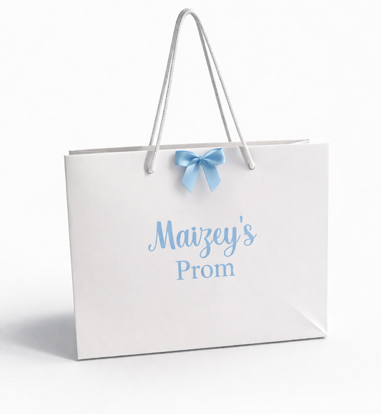 White gift bag with 'Maizey's Prom' text and a blue bow on a white background