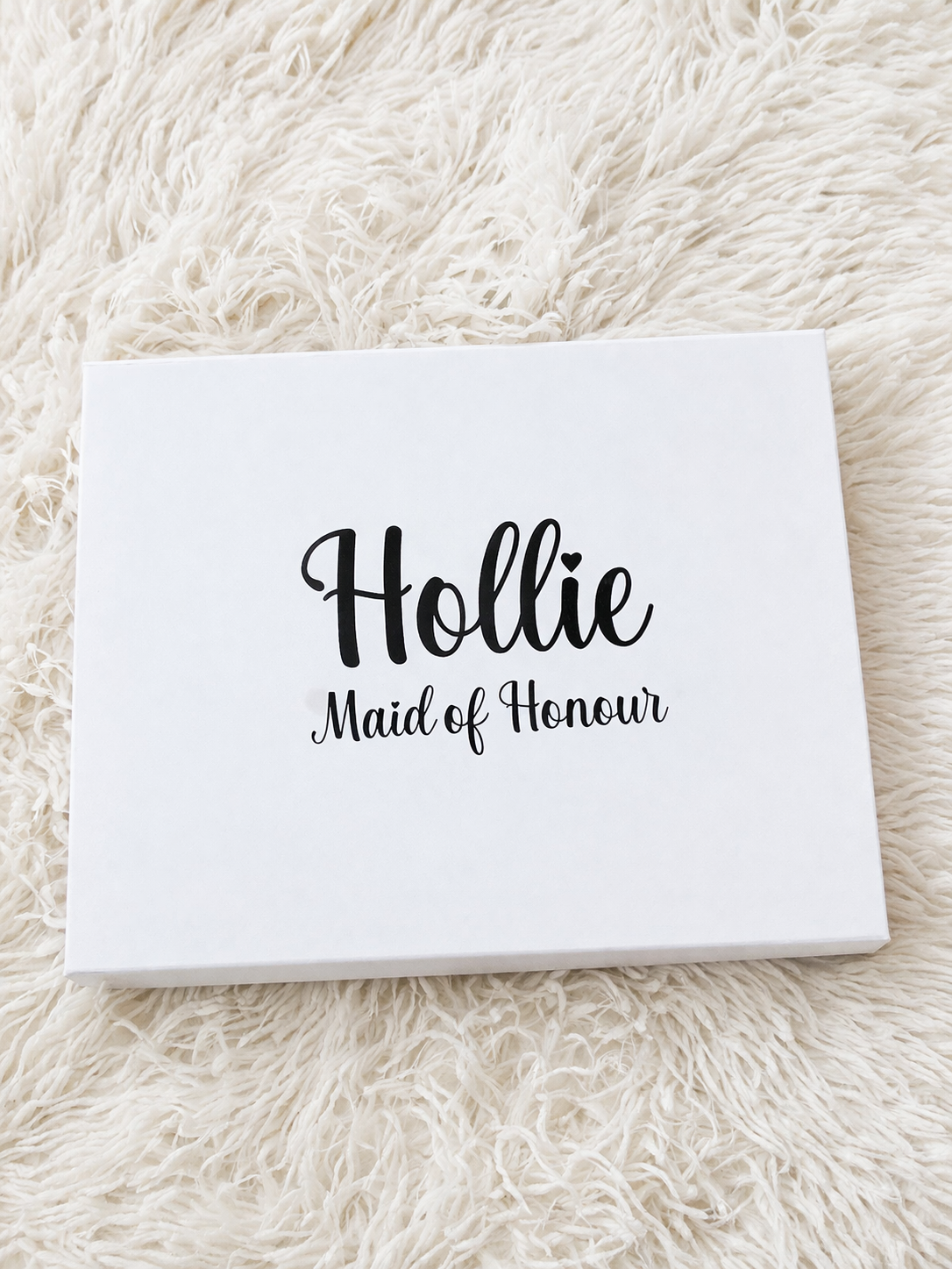 White card with 'Hollie Maid of Honour' text on a fluffy white surface