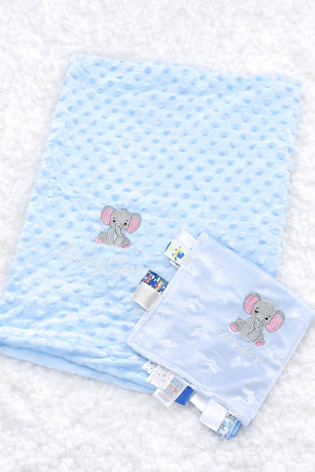 Blue baby blanket with elephant design on a textured white background