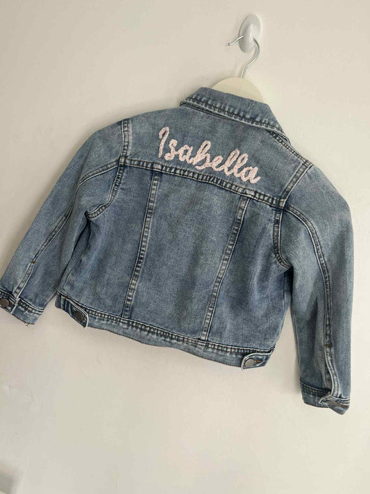 Denim jacket with 'Isabella' embroidered on a white background