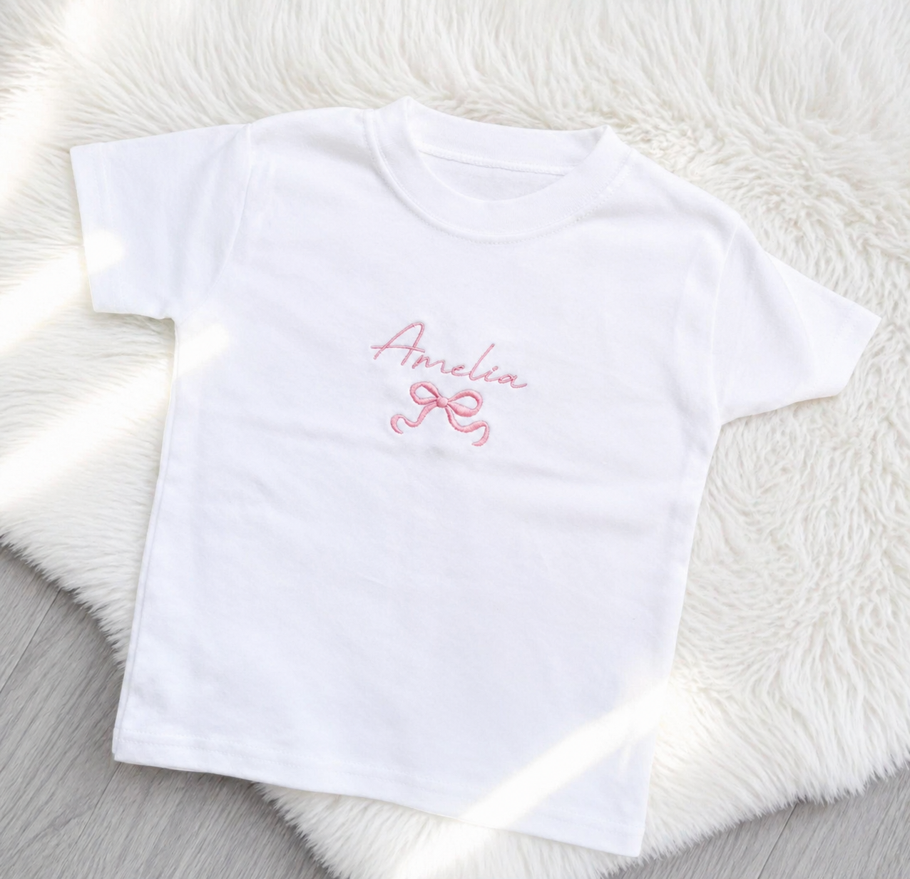 Personalised kids T-shirt with embroidered script name and bow detail on white top