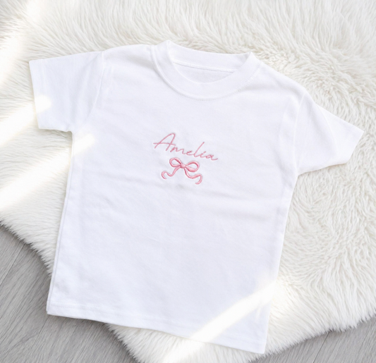 Personalised kids T-shirt with embroidered script name and bow detail on white top