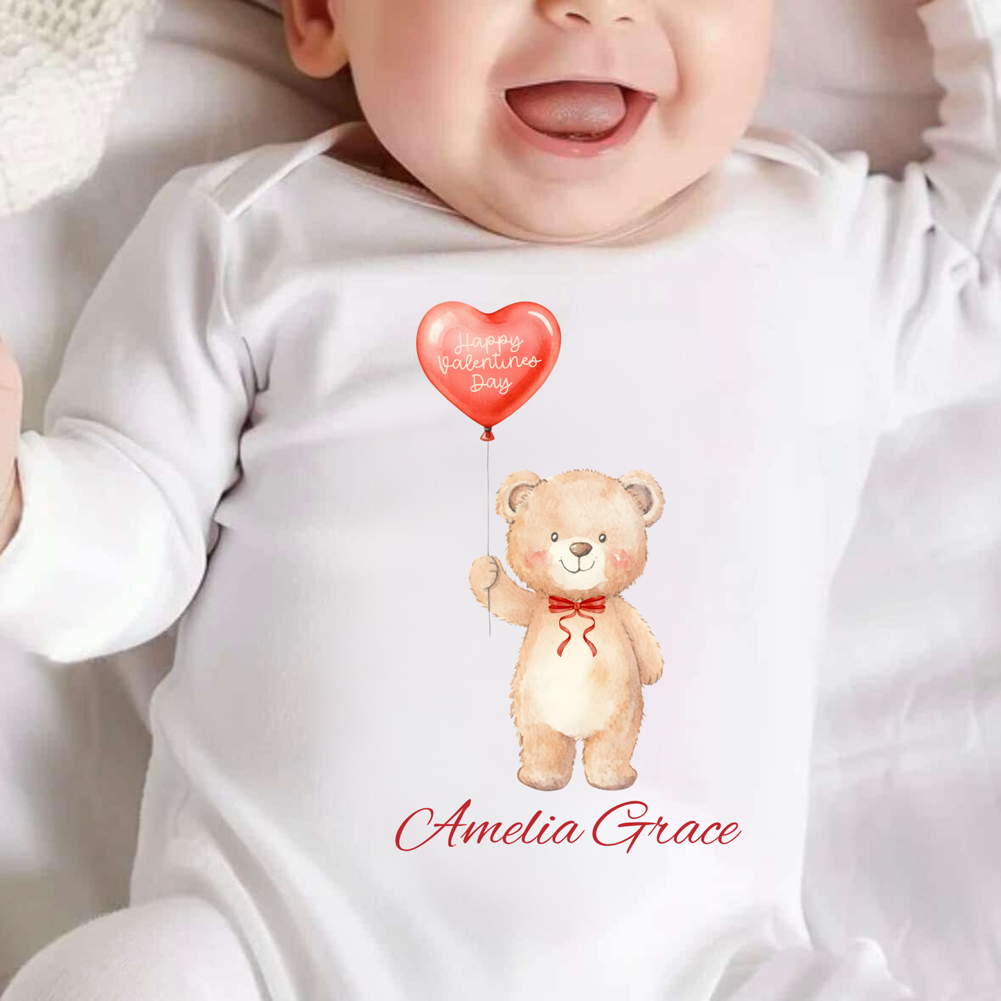 Baby wearing a white onesie with a teddy bear and heart design, personalized with 'Amelia Grace'.