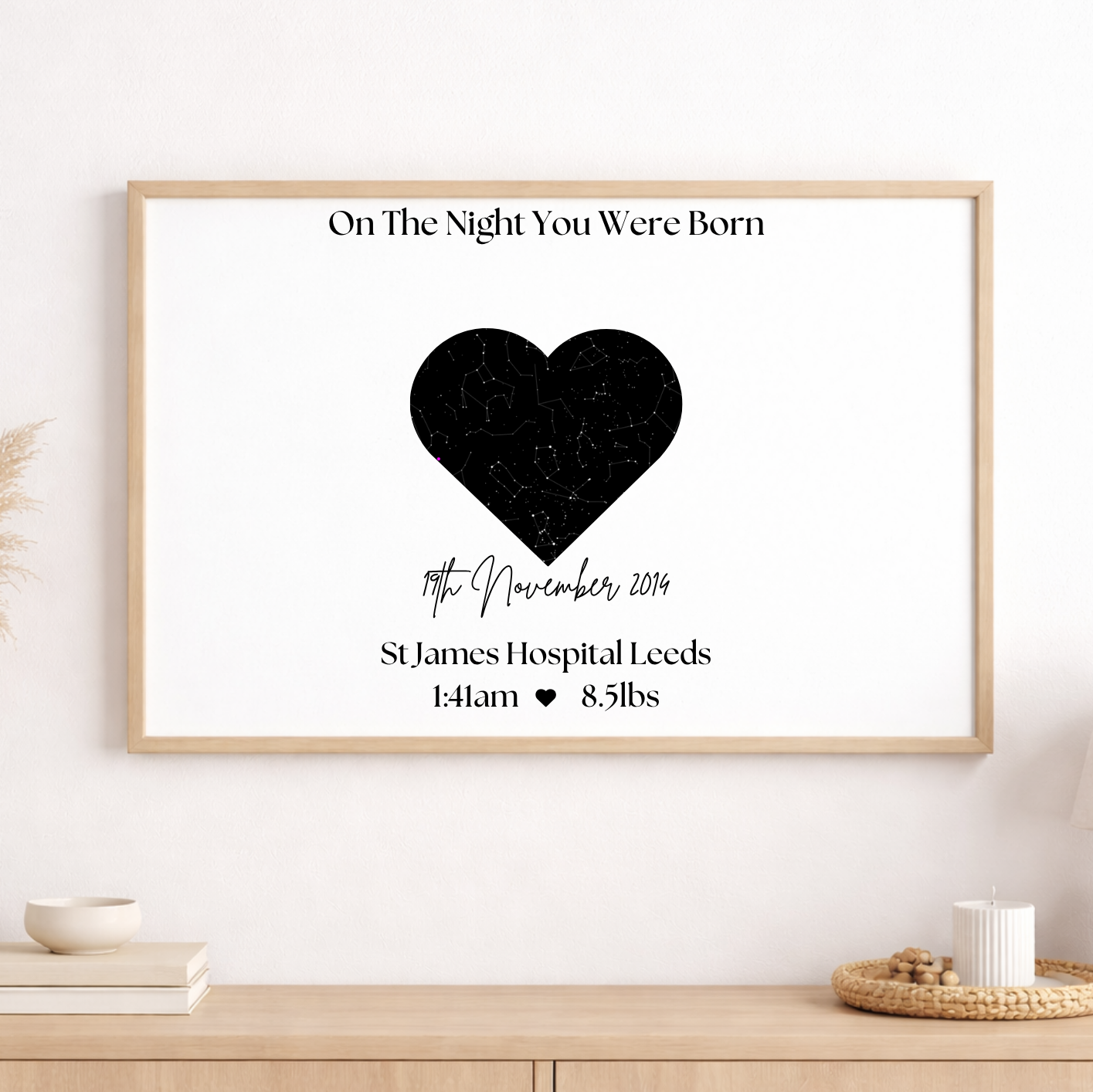 Framed artwork with a black heart design on a white wall