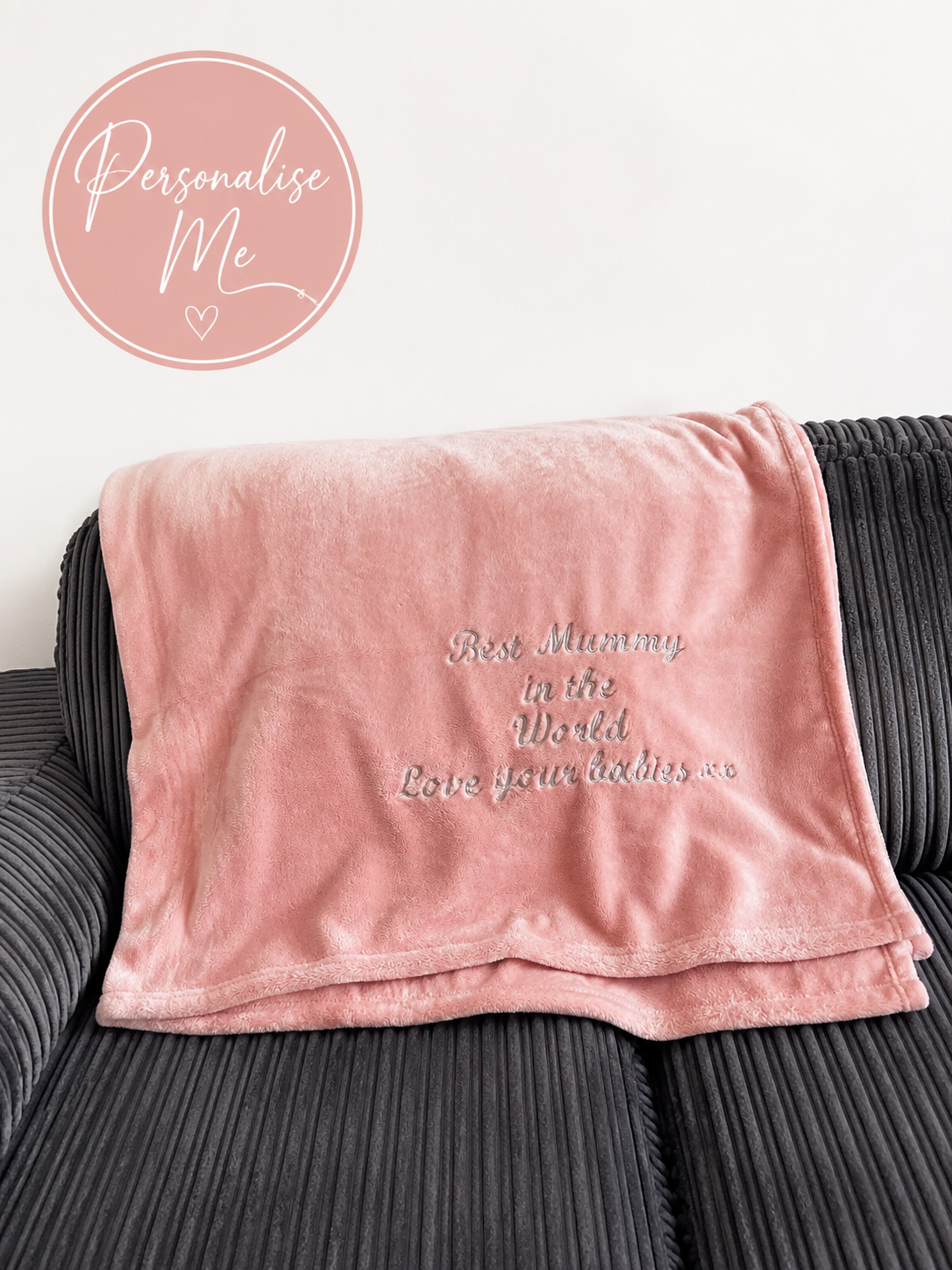 Personalised pink embroidered fleece blanket with custom text displayed on soft neutral background