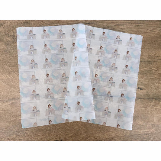 Two sheets of personalised business packing paper with multiple copies of a business logo printed on each sheet, laid on a wooden surface.