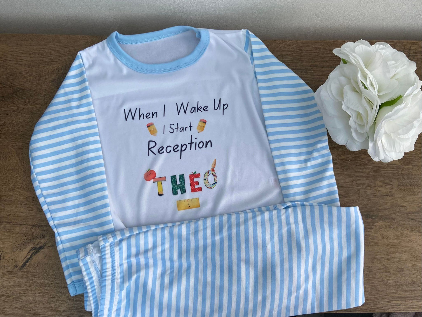 A personalized children's pyjama set with blue and white stripes, featuring text and graphics related to school admission.