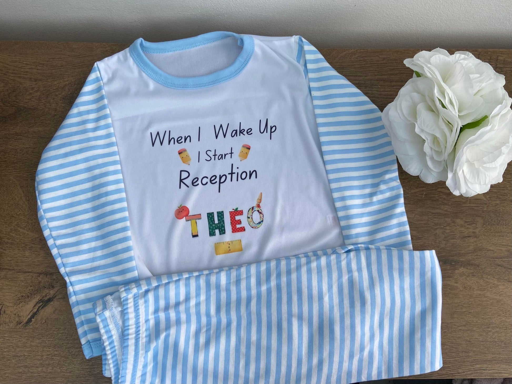 A personalized children's pyjama set with blue and white stripes, featuring text and graphics related to school admission.