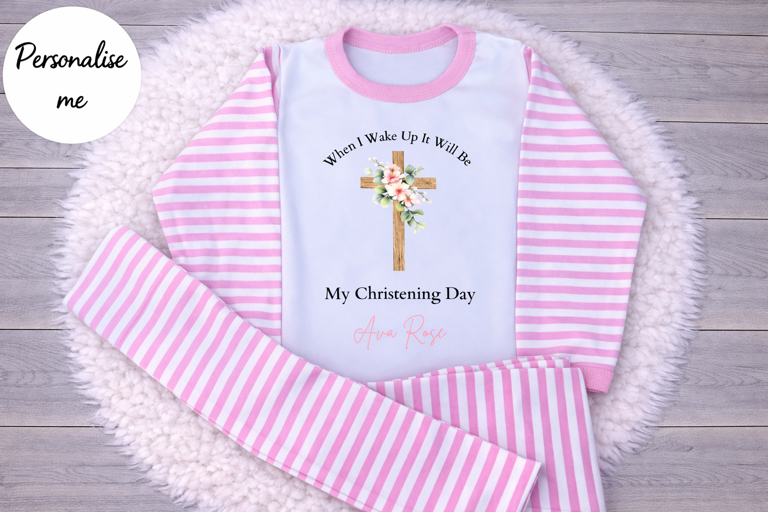 Pink and white striped pajama set with a personalized message on a wooden surface.