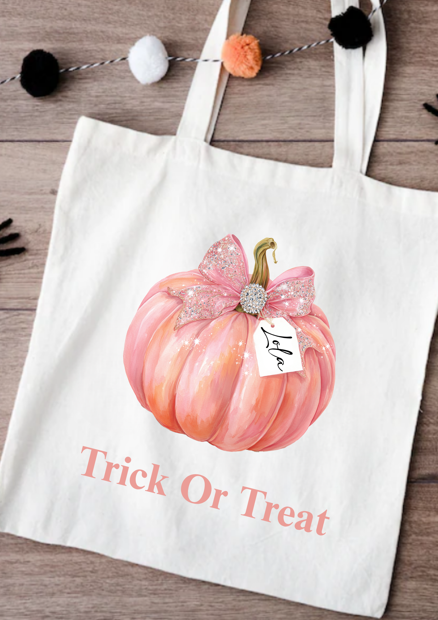 Tote bag with a pink pumpkin and 'Trick or Treat' text on a wooden surface.