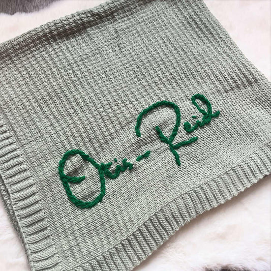 Sage green personalised knitted baby blanket with embroidered name "Otis-Reid"