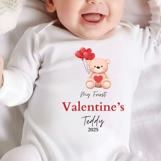 Baby wearing a onesie with a teddy bear and heart balloons design, celebrating Valentine's Day.