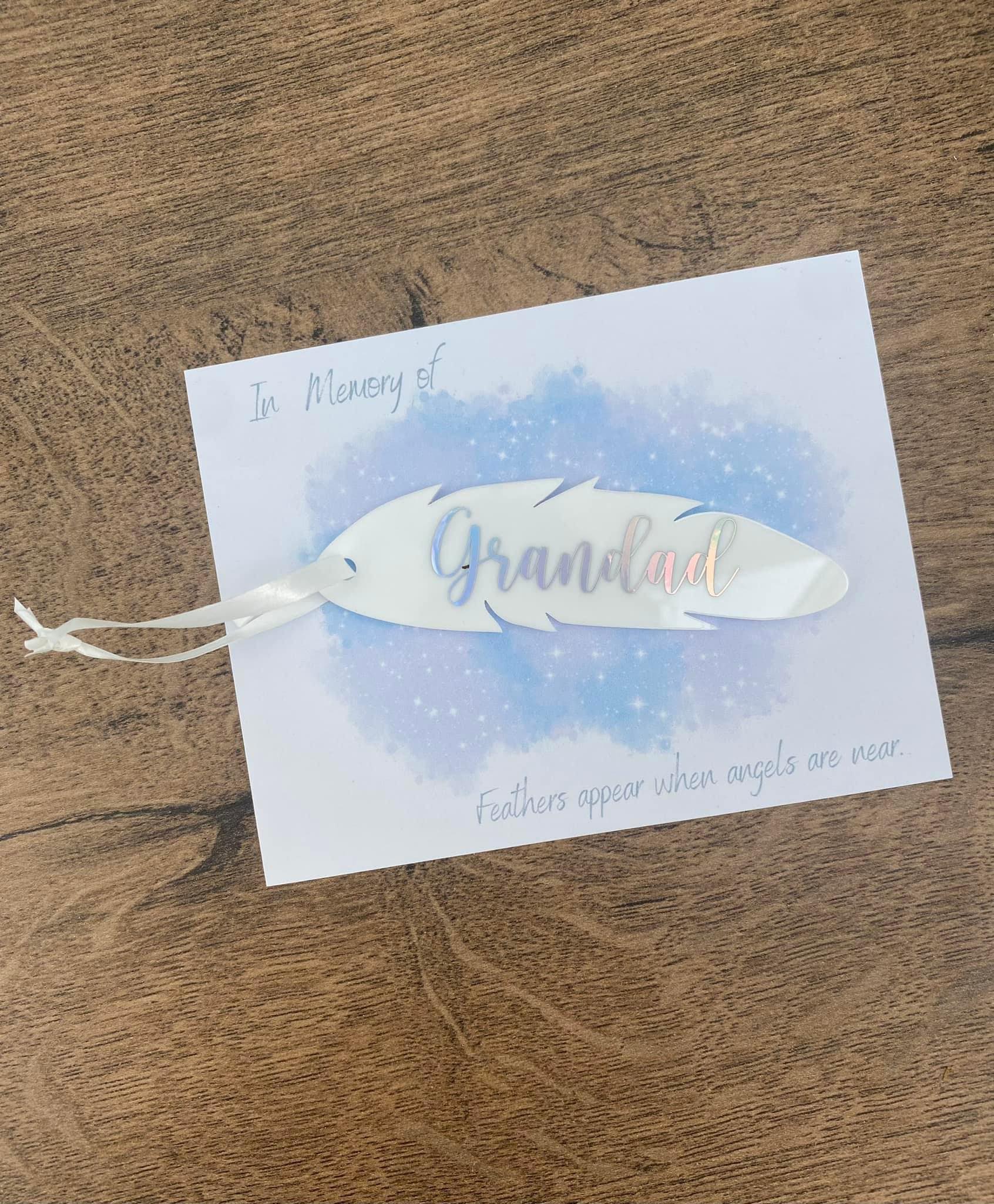 White acrylic Memorial Feather gift with text saying grandad in silver on card backing.