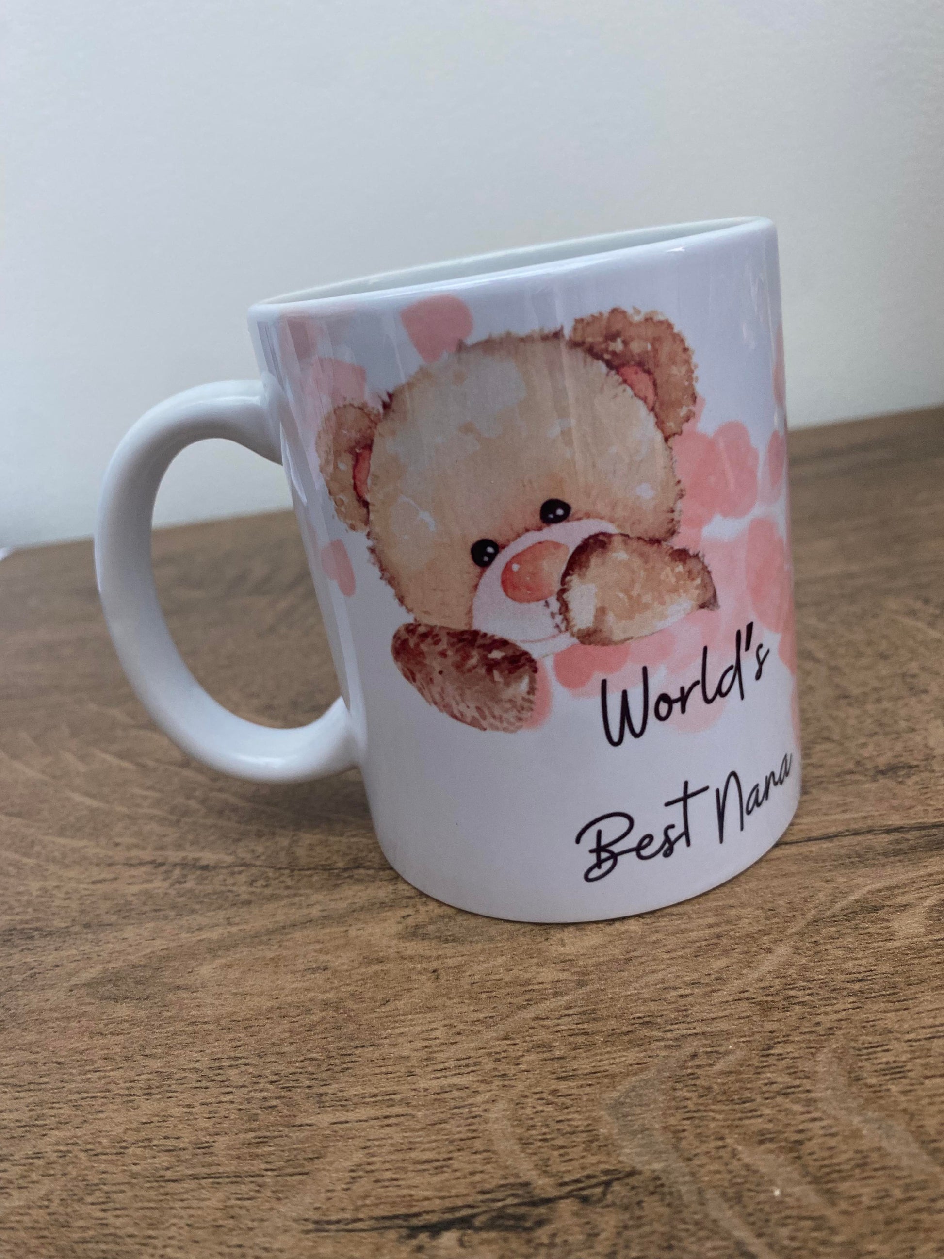 A white ceramic mug with an illustration of a teddy bear and the text 'World's Best Nana'.